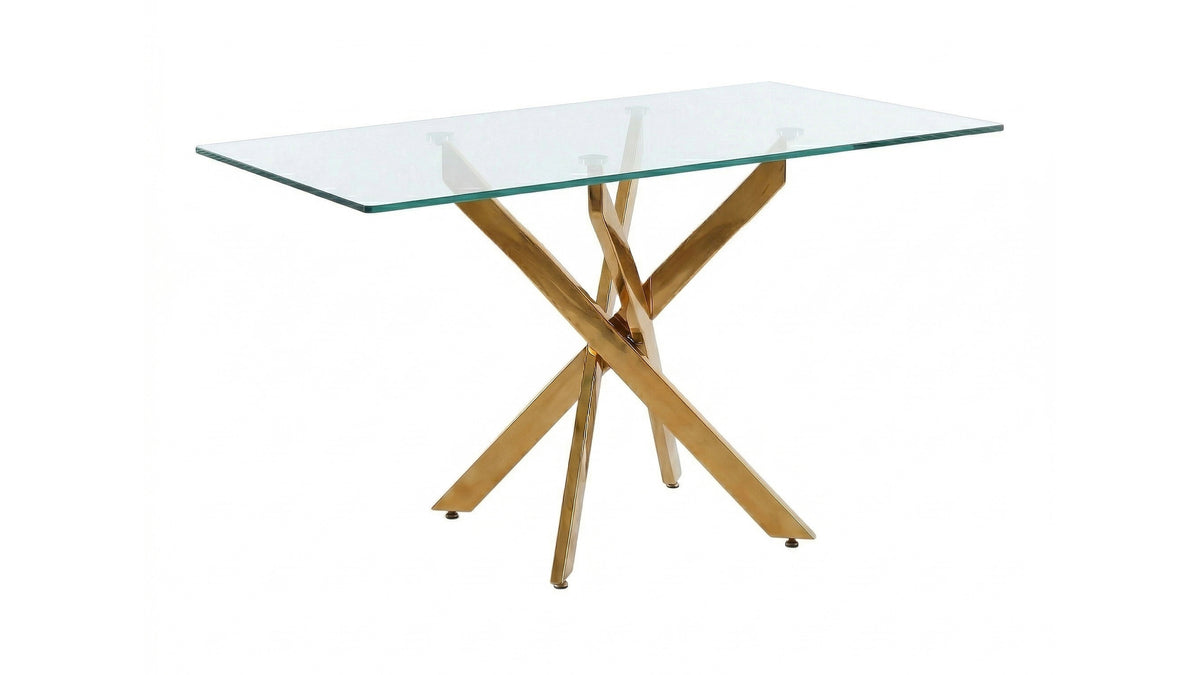 Wide side-angled studio view of the glass dining table with gold crisscross legs