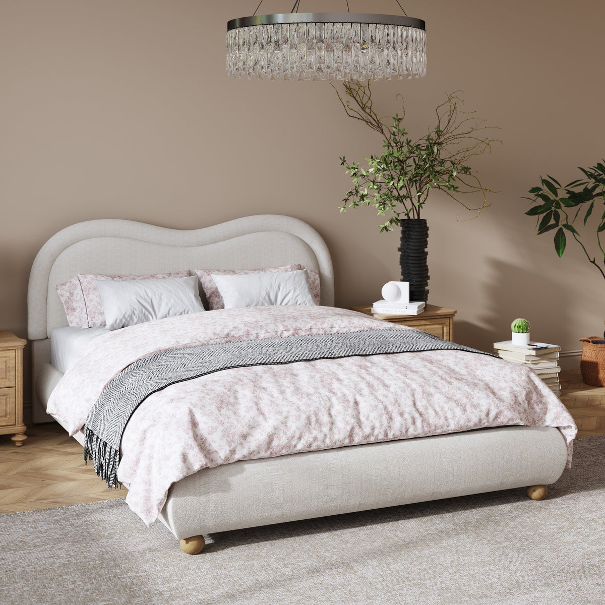 Angled beige chenille curved-headboard bed with pink floral bedding in a warm bedroom