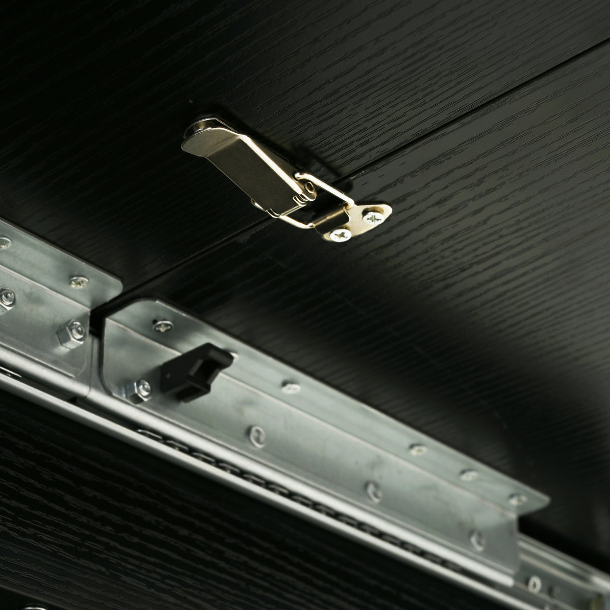 Close-up of the underside slide rail, toggle latch and black stopper
