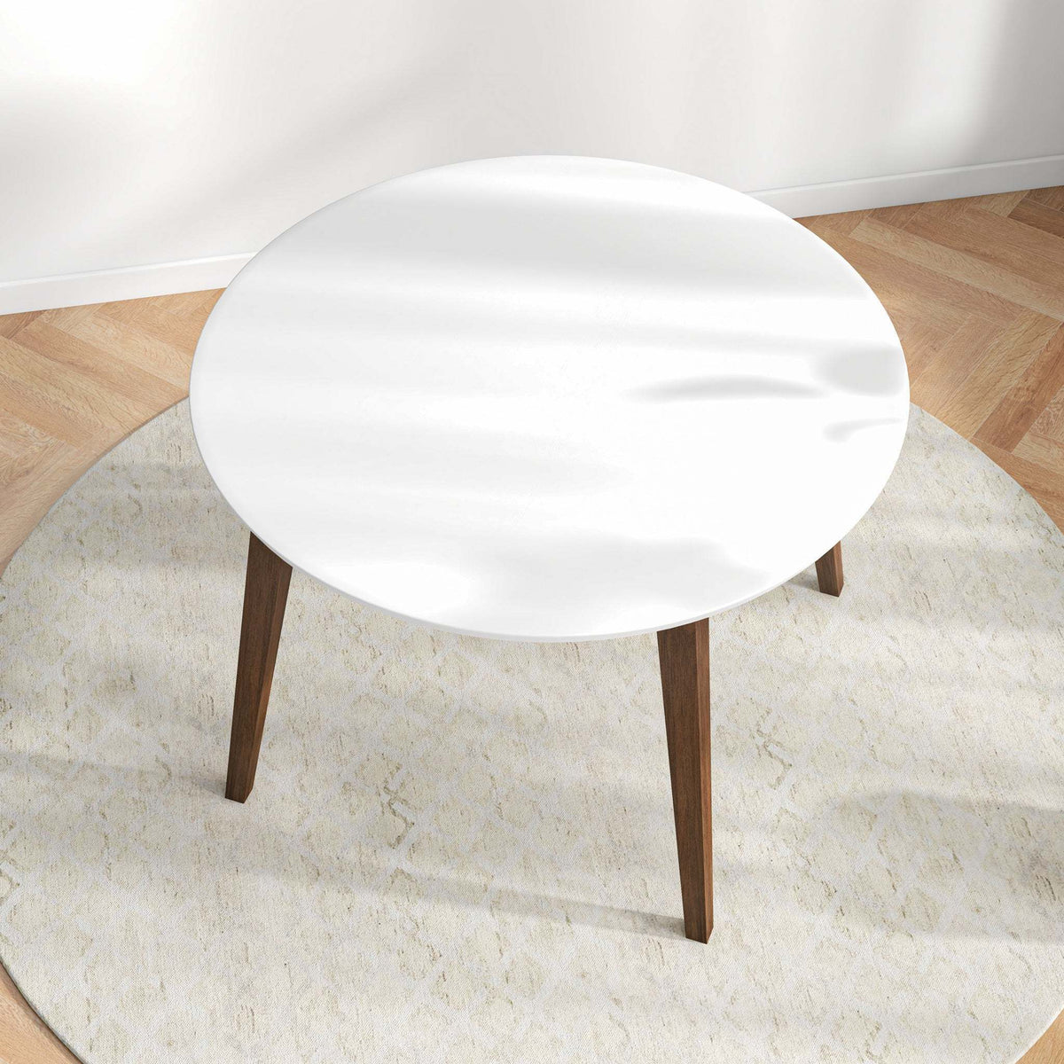 Overhead angled view of the white round dining table in a styled room