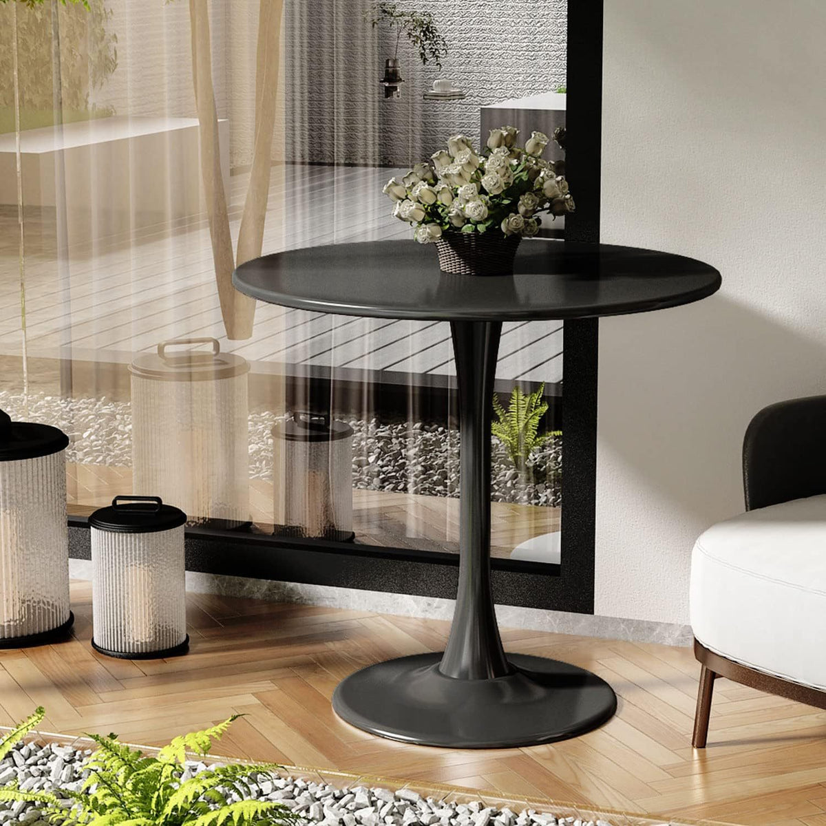 Round black tulip table with white roses in a modern room by a glass wall