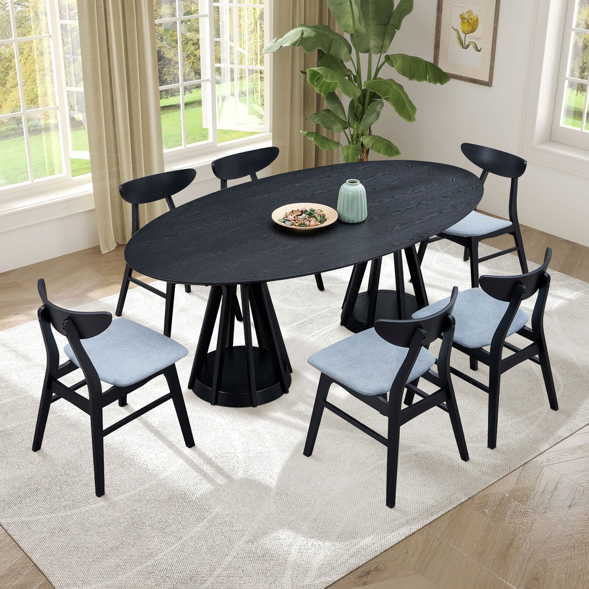 Overhead room view of the black oval pedestal dining table with six chairs
