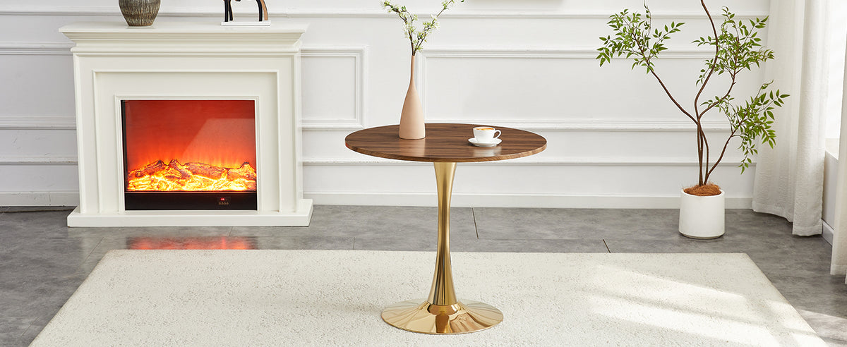 Walnut-top gold-base dining table in a sunlit room with a fireplace and potted tree, three-quarter view