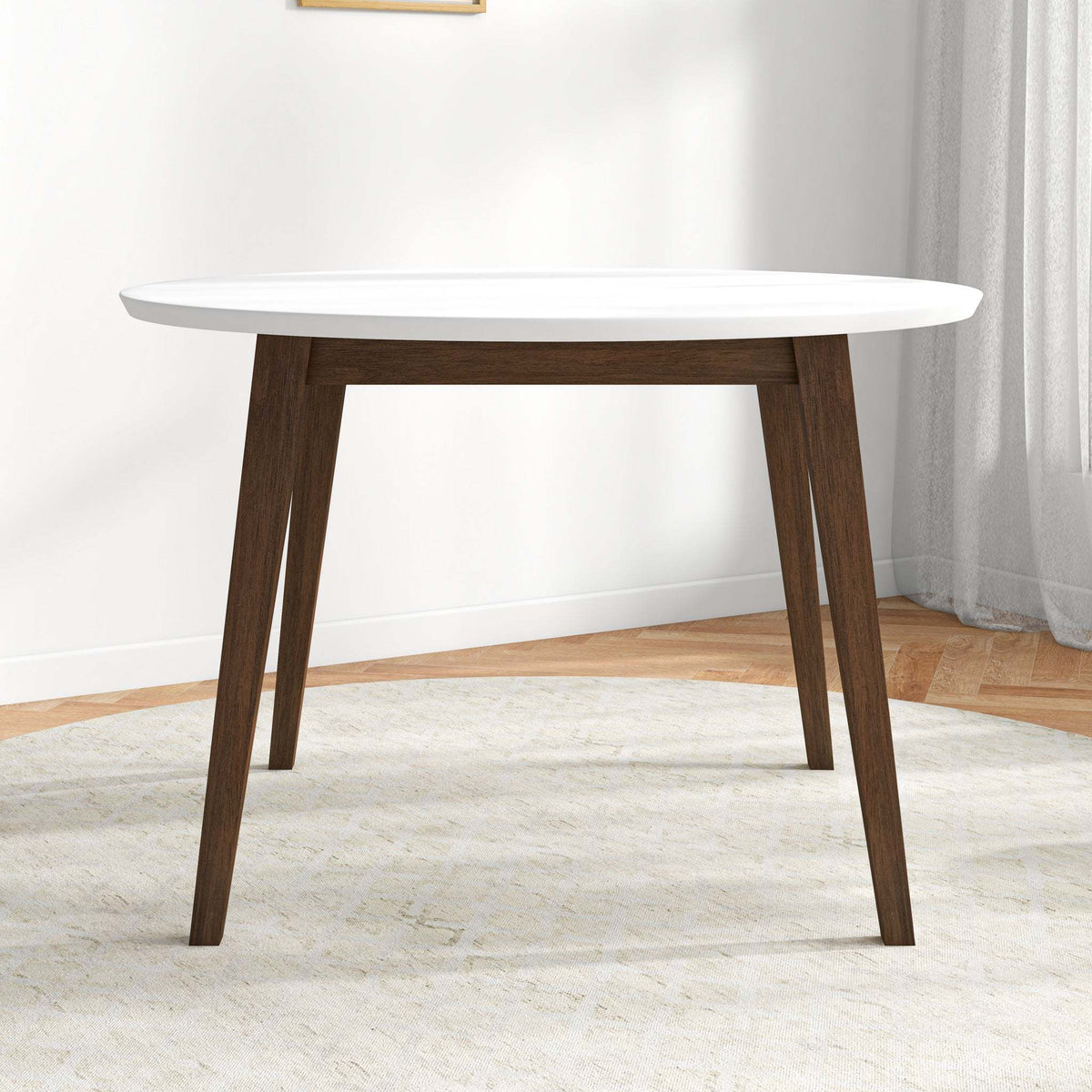 White round dining table, front view in a styled room with a window