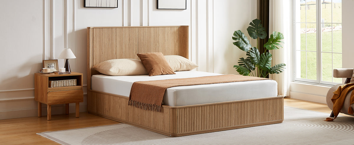 Angled bedroom view of the natural oak fluted platform bed beside an oak nightstand and lamp