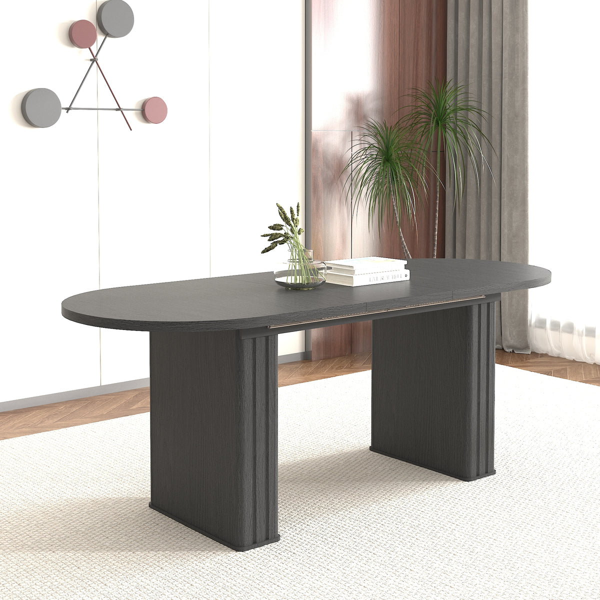 Angled view of the black oval extendable dining table in a bright room with a tall potted plant
