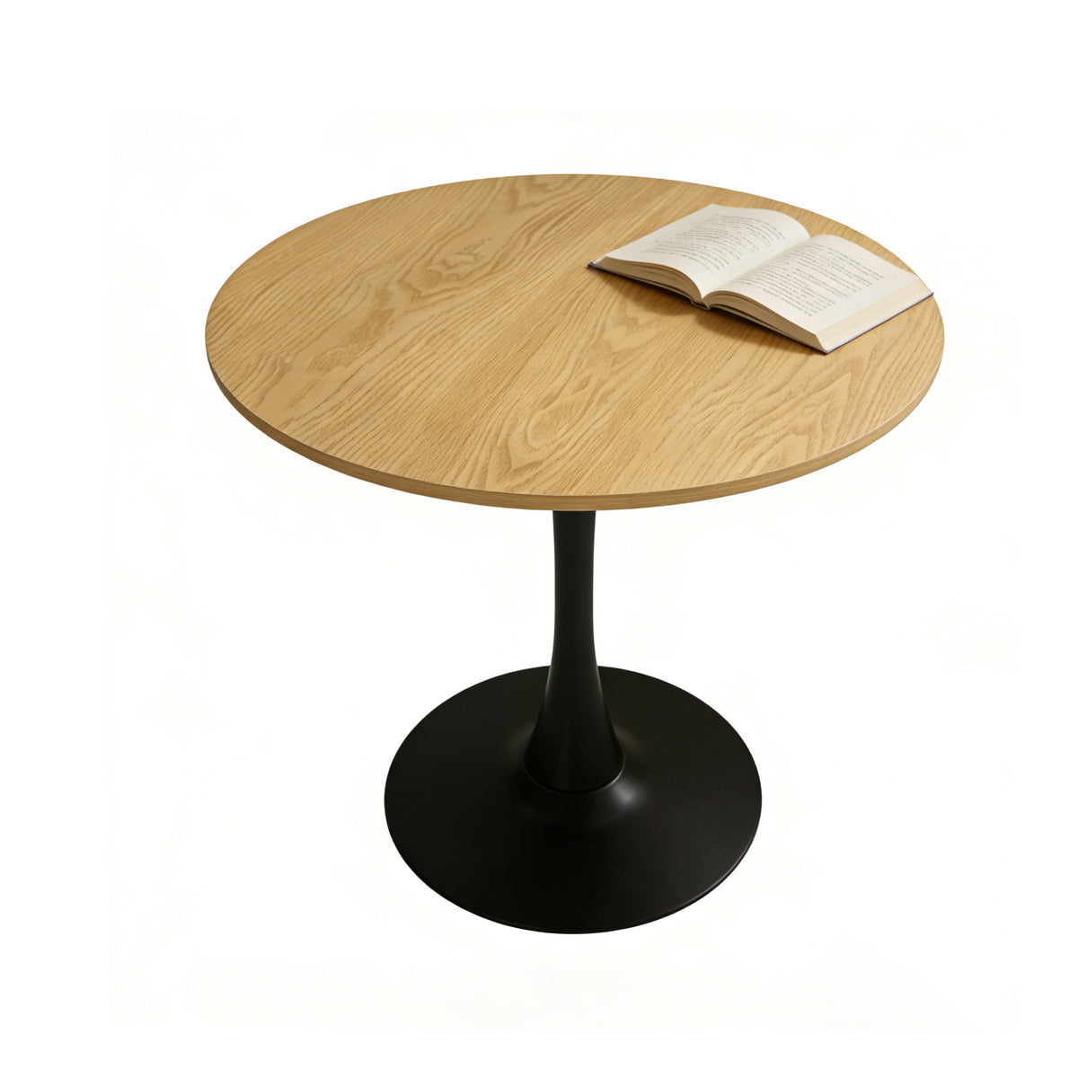 Natural round pedestal dining table on a plain white studio background with an open book on top